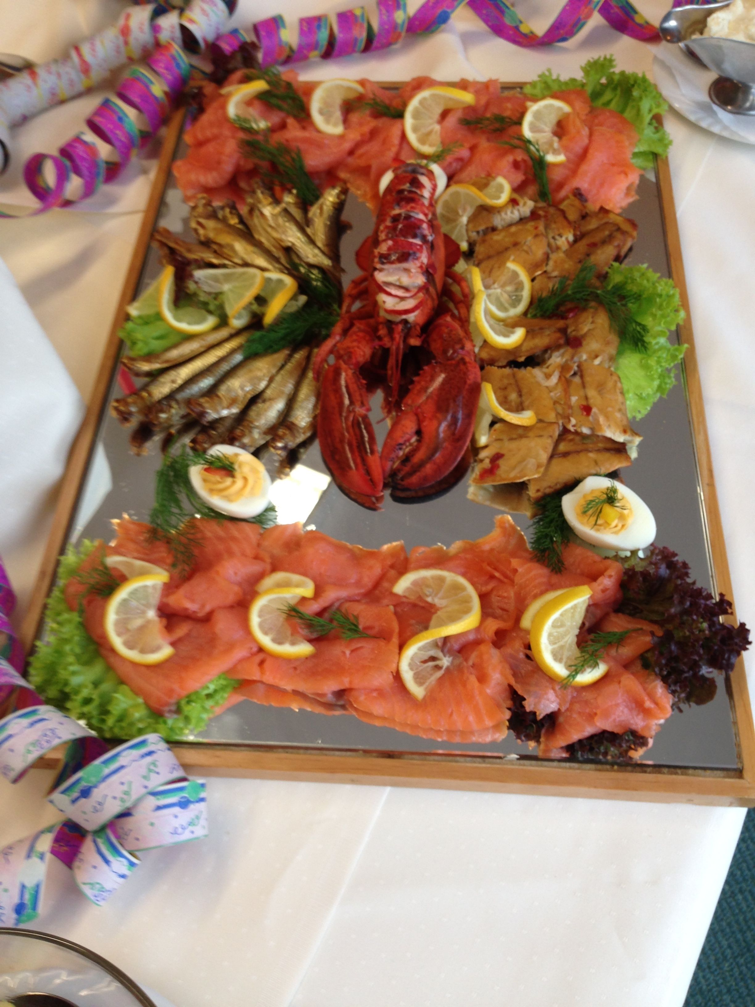 A platter of food including salmon, eggs, and a lobster.