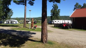 A campsite with RVs, a tent, and a dirt path. - Ljusdals Camping (Ljusdal)