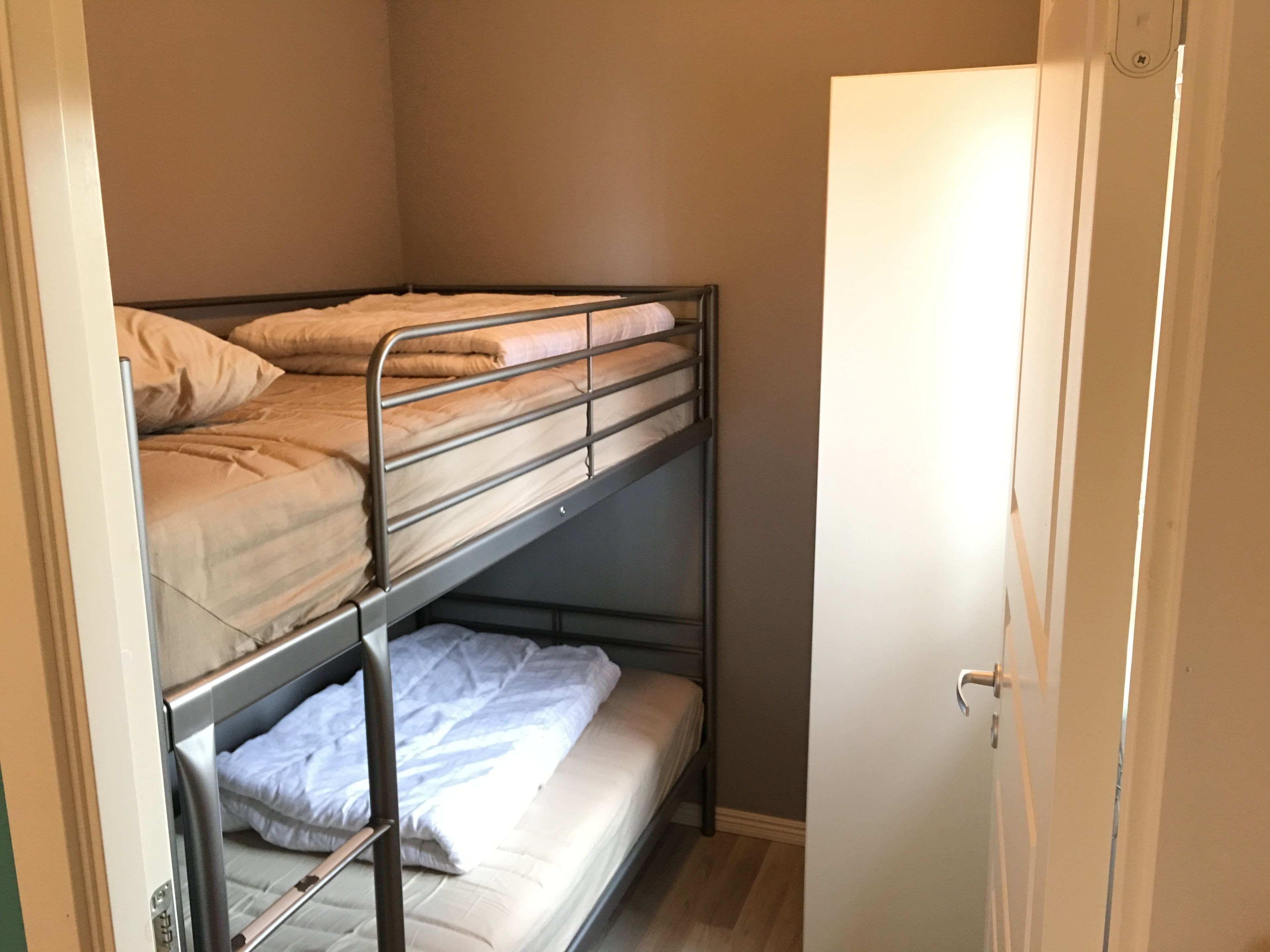 Habitación con literas, una puerta y un interruptor de luz en la pared.