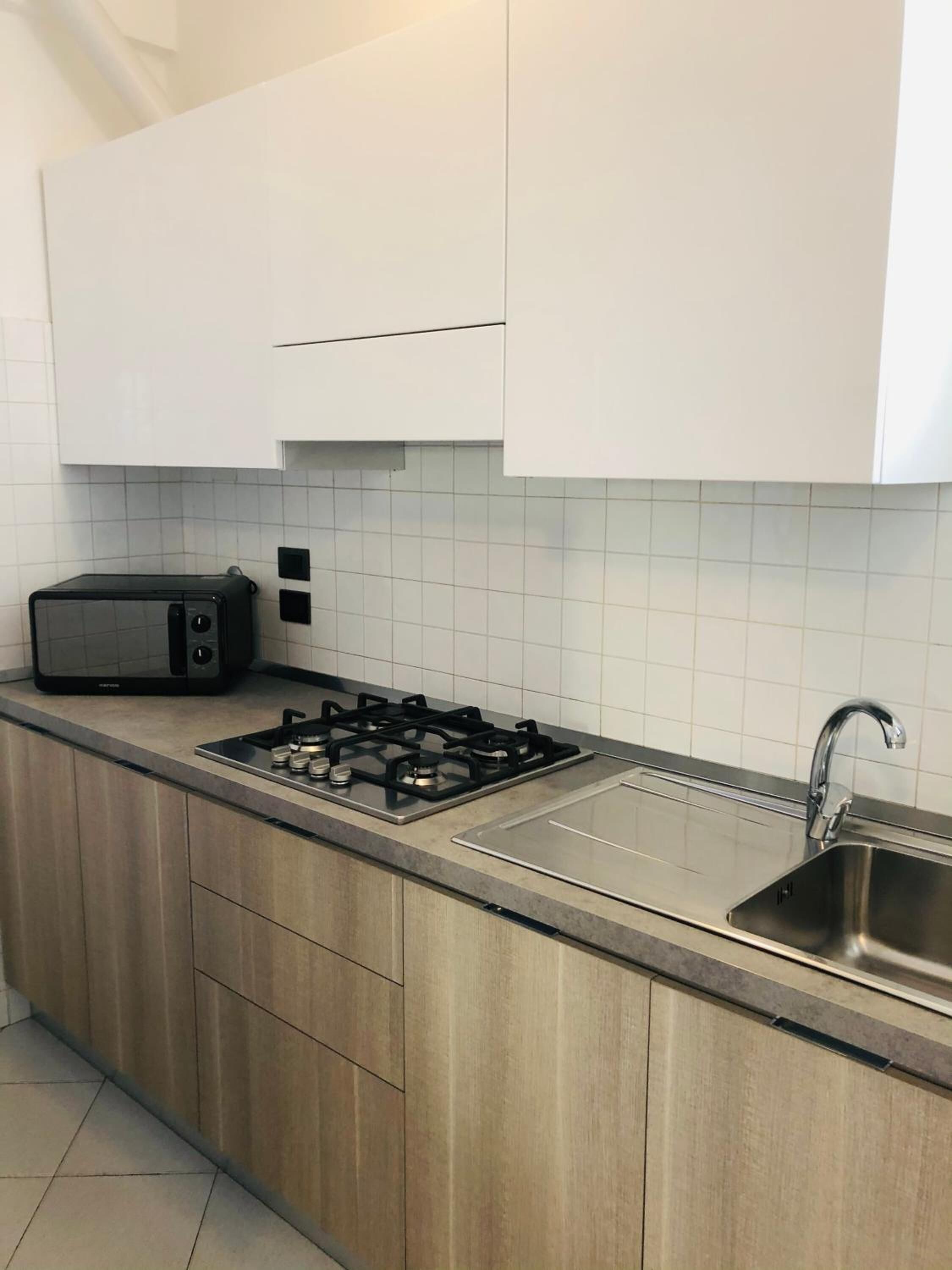 A modern kitchen with a gas stove, a built-in toaster, and a stainless steel sink.