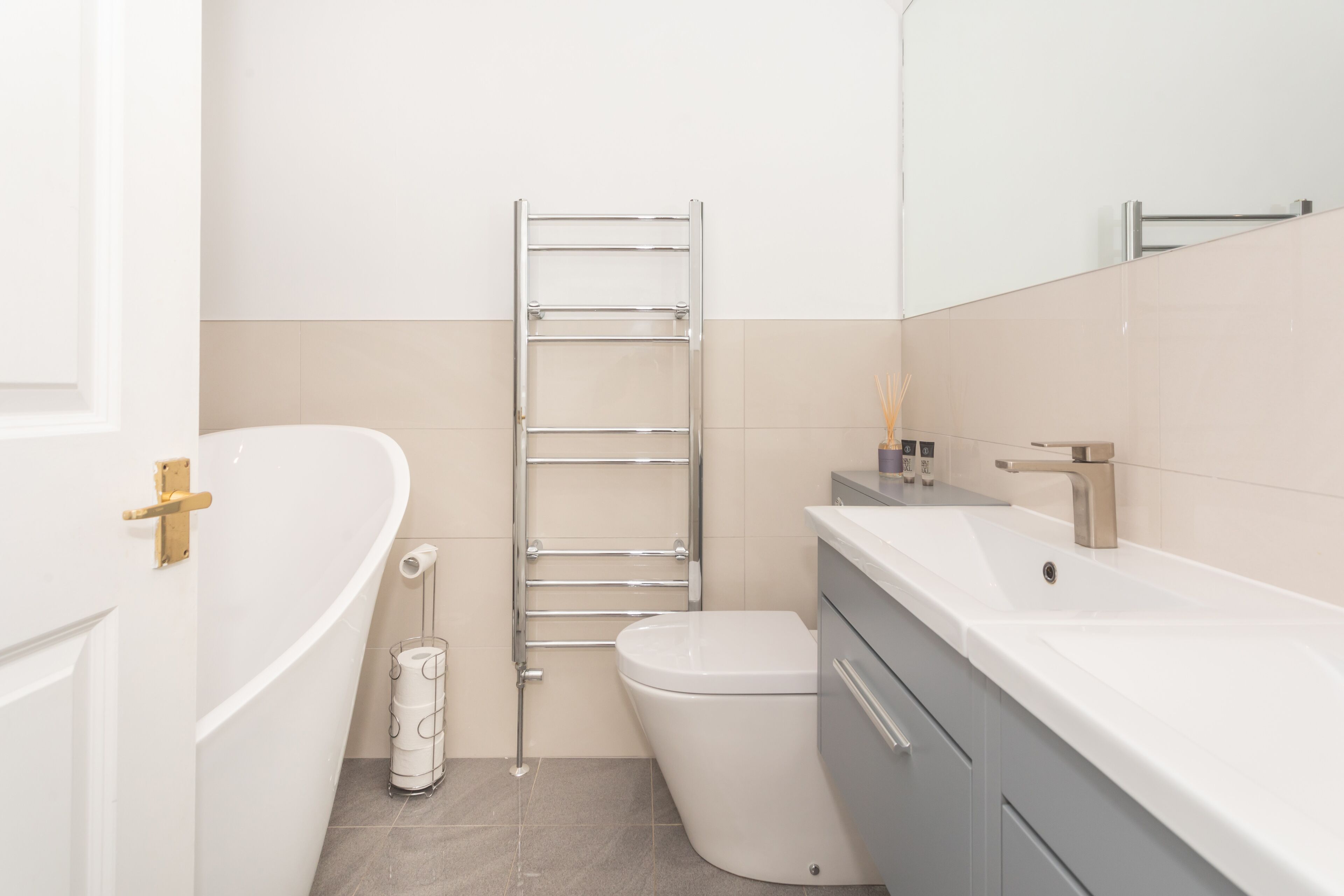 A modern bathroom with a bathtub, toilet, and vanity.