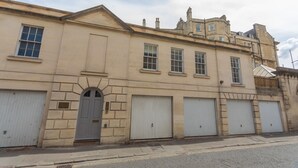 Un edificio histórico con fachada simétrica, ventanas grandes y un arco central.