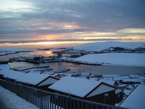 A coastal town with snow-covered buildings and a marina. - Easterhoull Chalets (Scalloway)