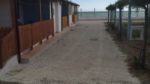 Un sendero que lleva a un edificio con cerramiento de madera y vista al mar.