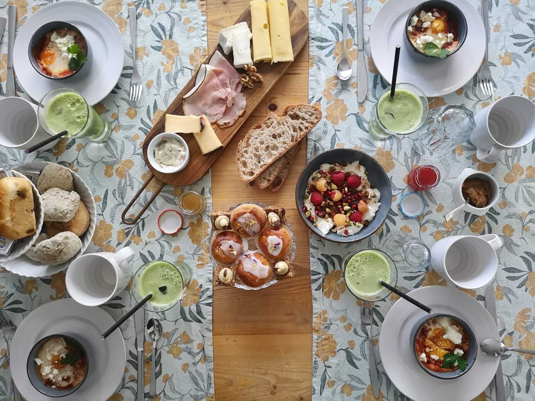 A table set with various dishes including cheese, bread, and a variety of drinks.