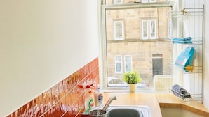 A kitchen with a window, a sink, and a mirror on the wall. - Easter Road Edinburgh Apartment (Edinburgh)