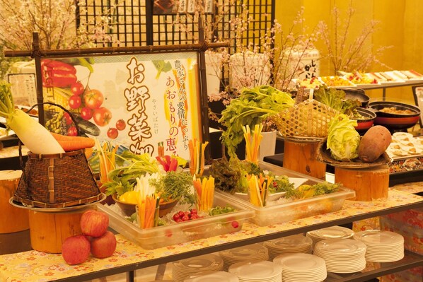 A buffet with various fruits, vegetables, and dishes.