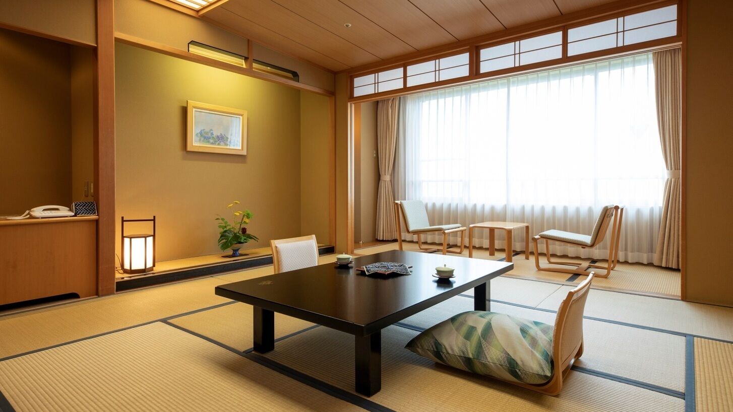 A traditional Japanese room with tatami flooring, a low table, and shoji screens.