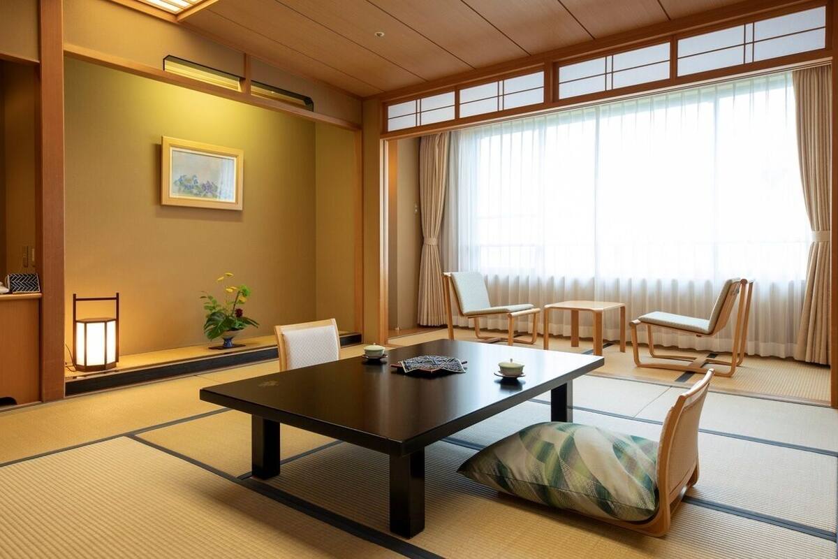 A traditional Japanese room with tatami flooring, a low table, and shoji screens.
