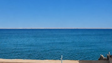 Uitzicht op zee vanaf een balkon met een heldere lucht.