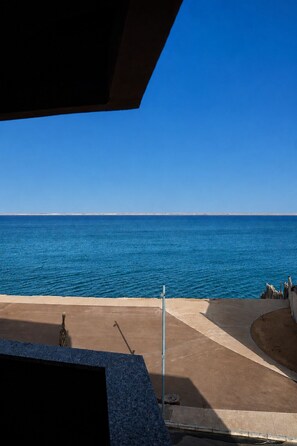 A view of the sea from a balcony with a clear sky.