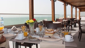 A dining area with a table set for breakfast, overlooking the sea. - Dakhla Sur Mer (Dakhla)