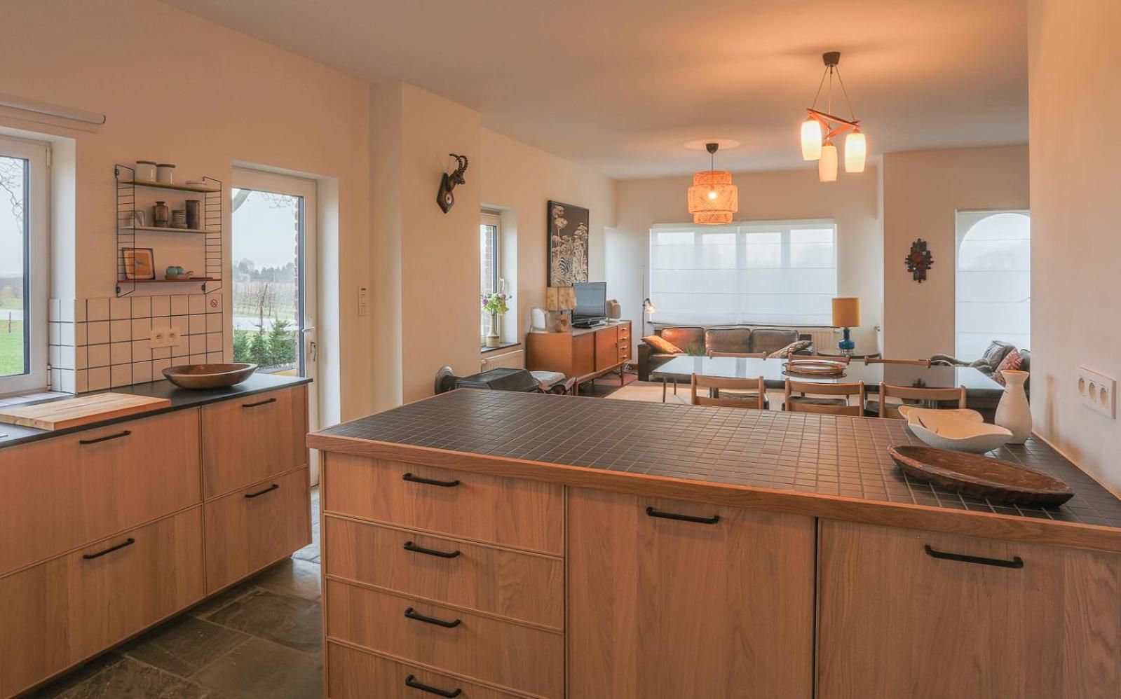 A spacious kitchen with a large island, wooden cabinets, and a dining area with a table and chairs.