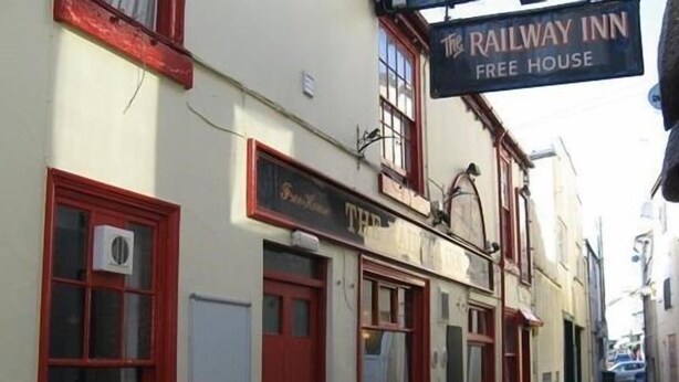 Ein Gebäude mit einem Schild, auf dem „The Railway Inn Free House“ steht.