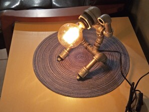 A table lamp with a glass shade and brass fittings on a woven placemat. - B Puli Backpacker Hostel (Puli)