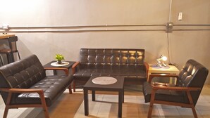 A living room with a sofa, two armchairs, a coffee table, and a small side table with a lamp. - B Puli Backpacker Hostel (Puli)