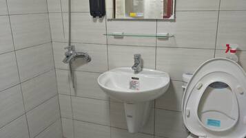 A bathroom with a white sink, a toilet, and a shower.