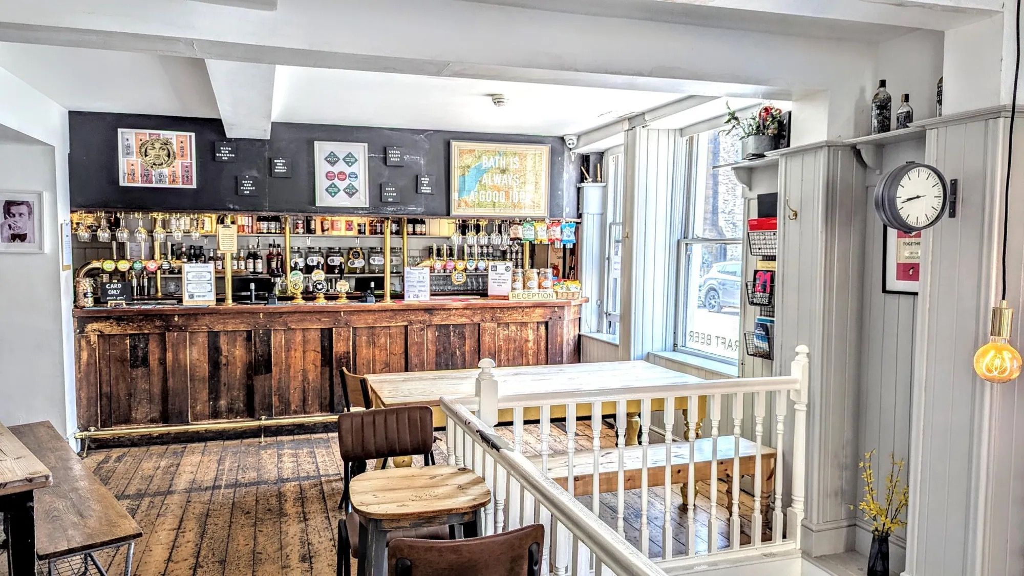Un bar con mostrador de madera, varias llaves y una zona de recepción.