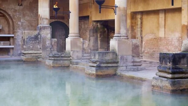 Un bâtiment historique doté d’une cour intérieure, de colonnes en pierre et d’une fontaine.