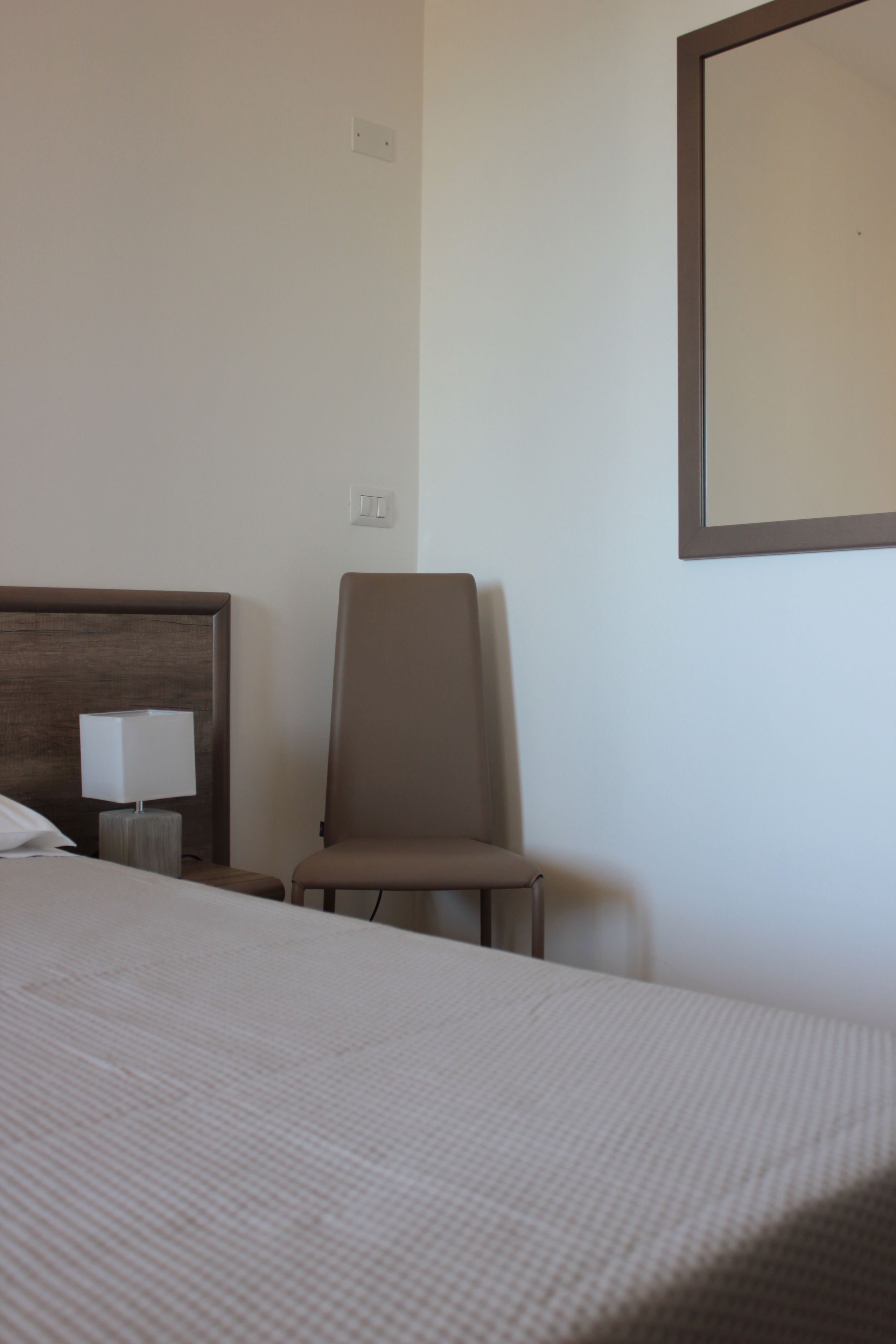 Ein Hotelzimmer mit einem Bett, einem Sessel und einer Lampe.