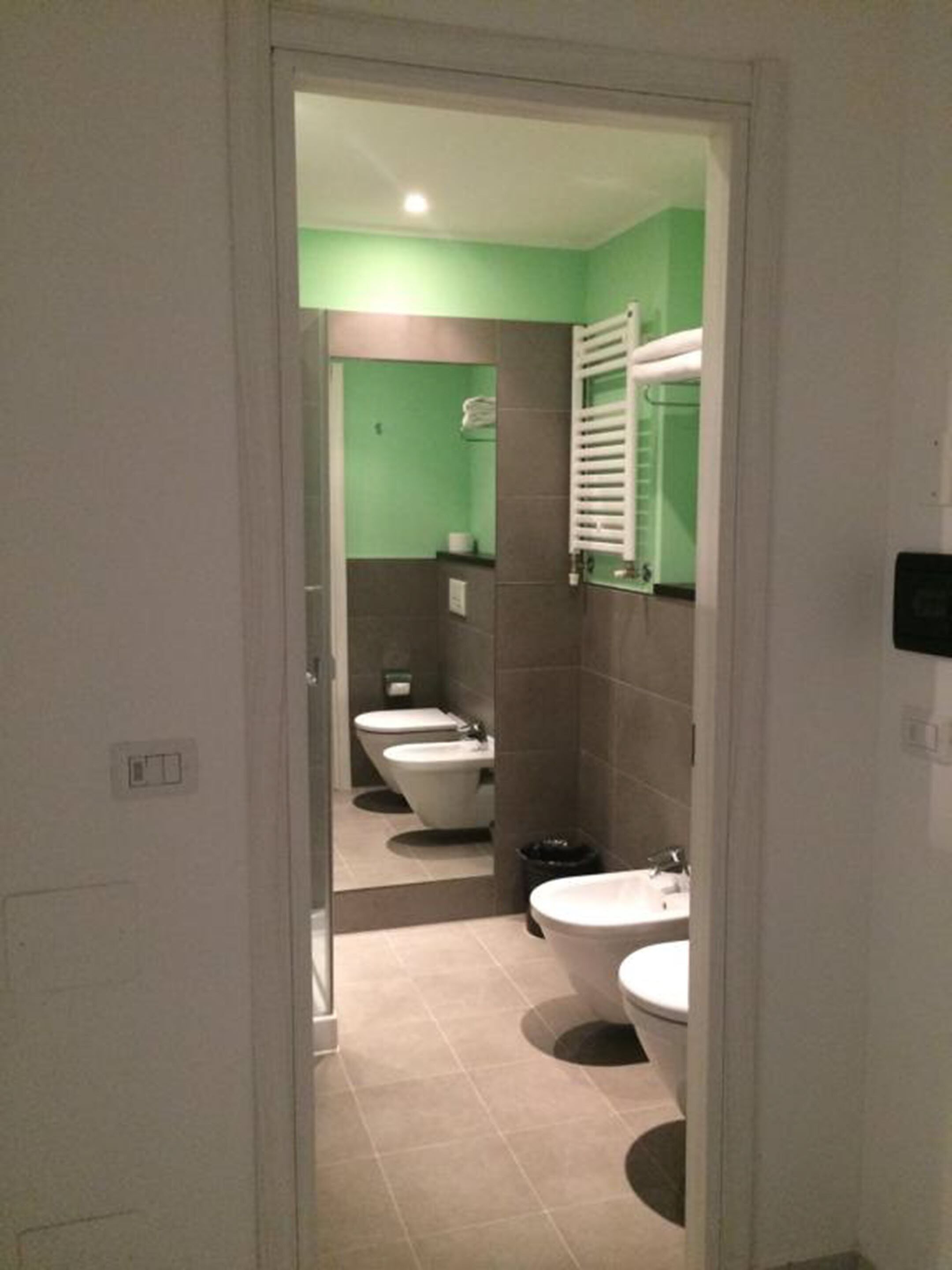 Un baño con dos inodoros, un bidé y un lavabo.