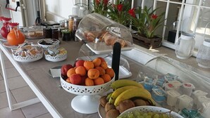 En morgenmadsbuffet med et udvalg af frugt, kager og drikkevarer.