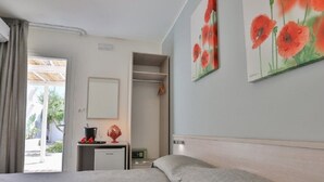 Et soveværelse med en seng, et natbord, et spejl og en dør til en balkon.