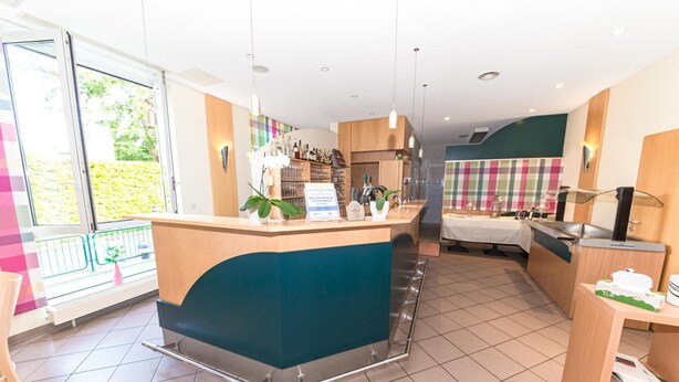 Een moderne hotellobby met een receptiebalie, een bar en een eetgedeelte.
