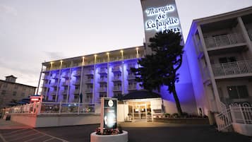 A hotel with a prominent marquee sign, multiple balconies, and a well-lit entrance.