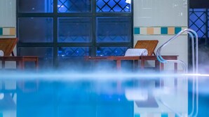 A pool area with lounge chairs and a glass railing. - Castletroy Park Hotel Suites (Limerick)