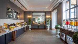 A modern hotel lobby with a long reception desk, a buffet area with various food items, and a large mirror reflecting the space. - Castletroy Park Hotel Suites (Limerick)