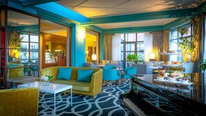 A modern lounge area with a piano, sofas, and a coffee station. - Castletroy Park Hotel Suites (Limerick)
