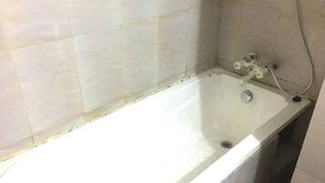 Una bañera estándar con cabezal de ducha y grifo, paredes con azulejos y desagüe.