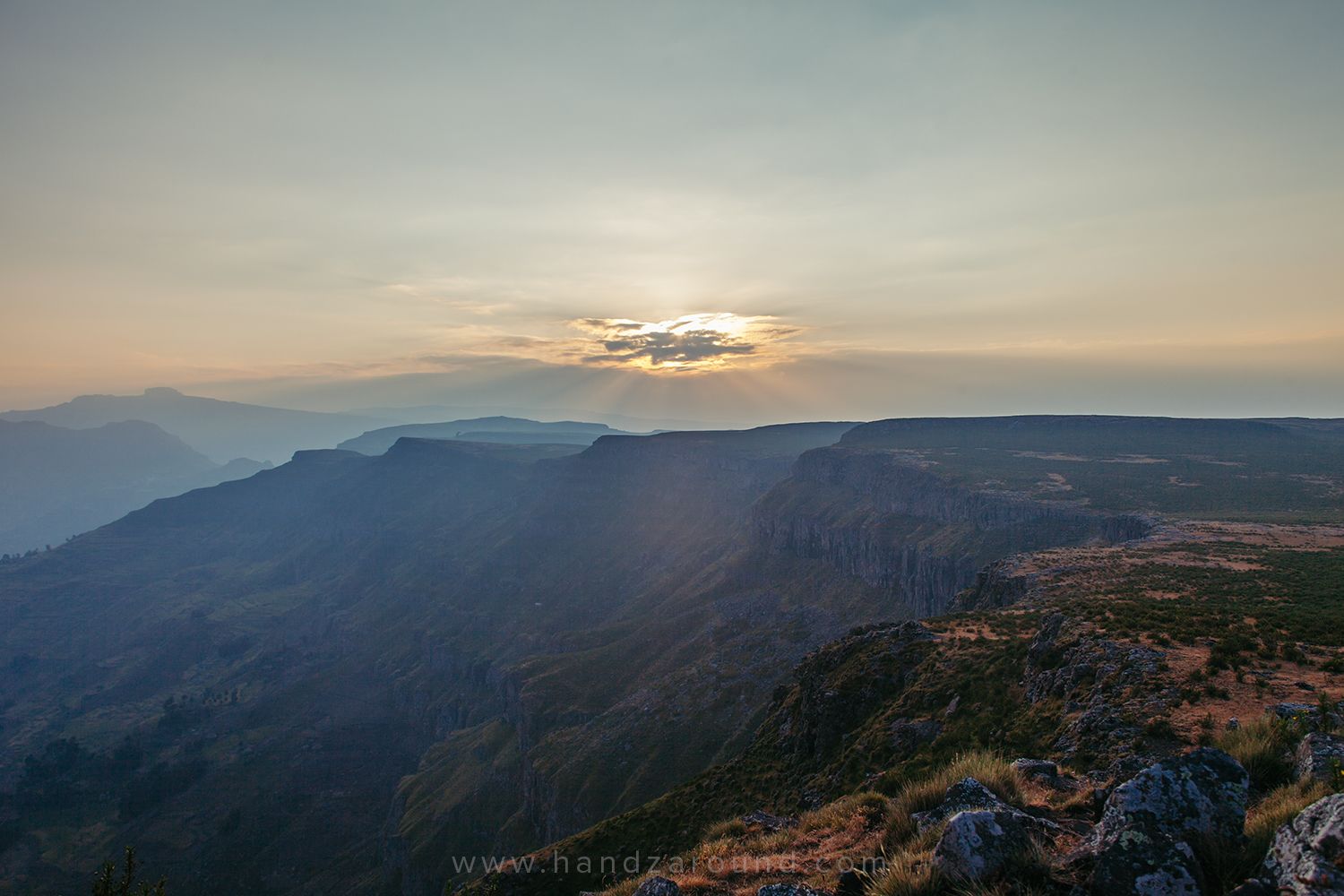 Un paysage montagneux avec une vallée et un ciel dégagé.