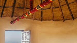 A room with a bed, a window with a view, and a thatched roof. - Degosach Eco Lodge (Lalibela)
