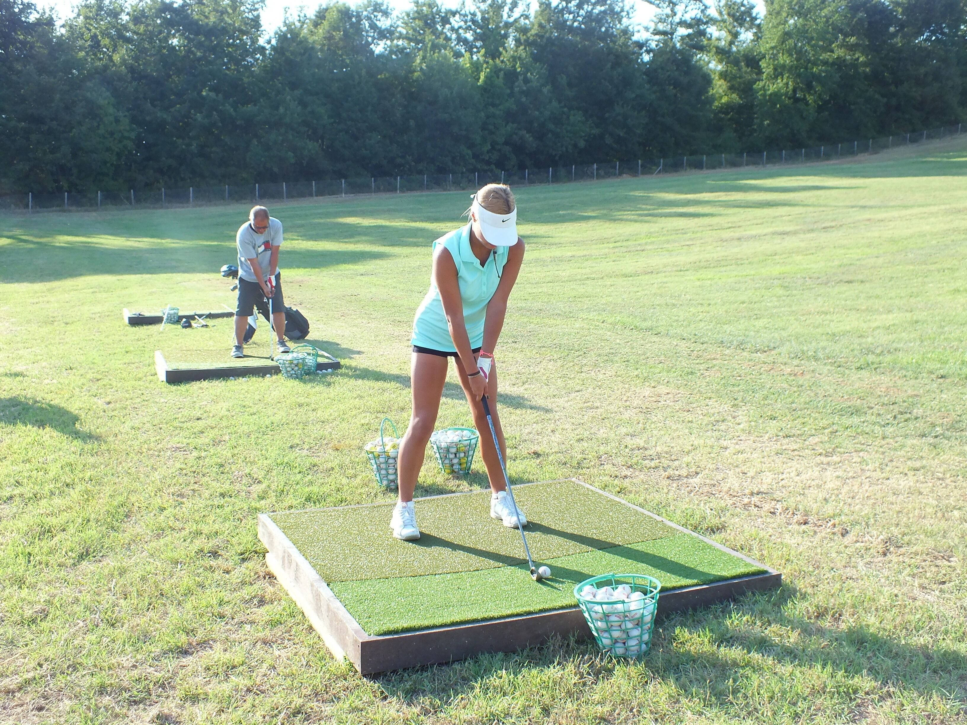 Eine Person übt Golf auf einem Grün mit Putting-Grün und Übungsloch.