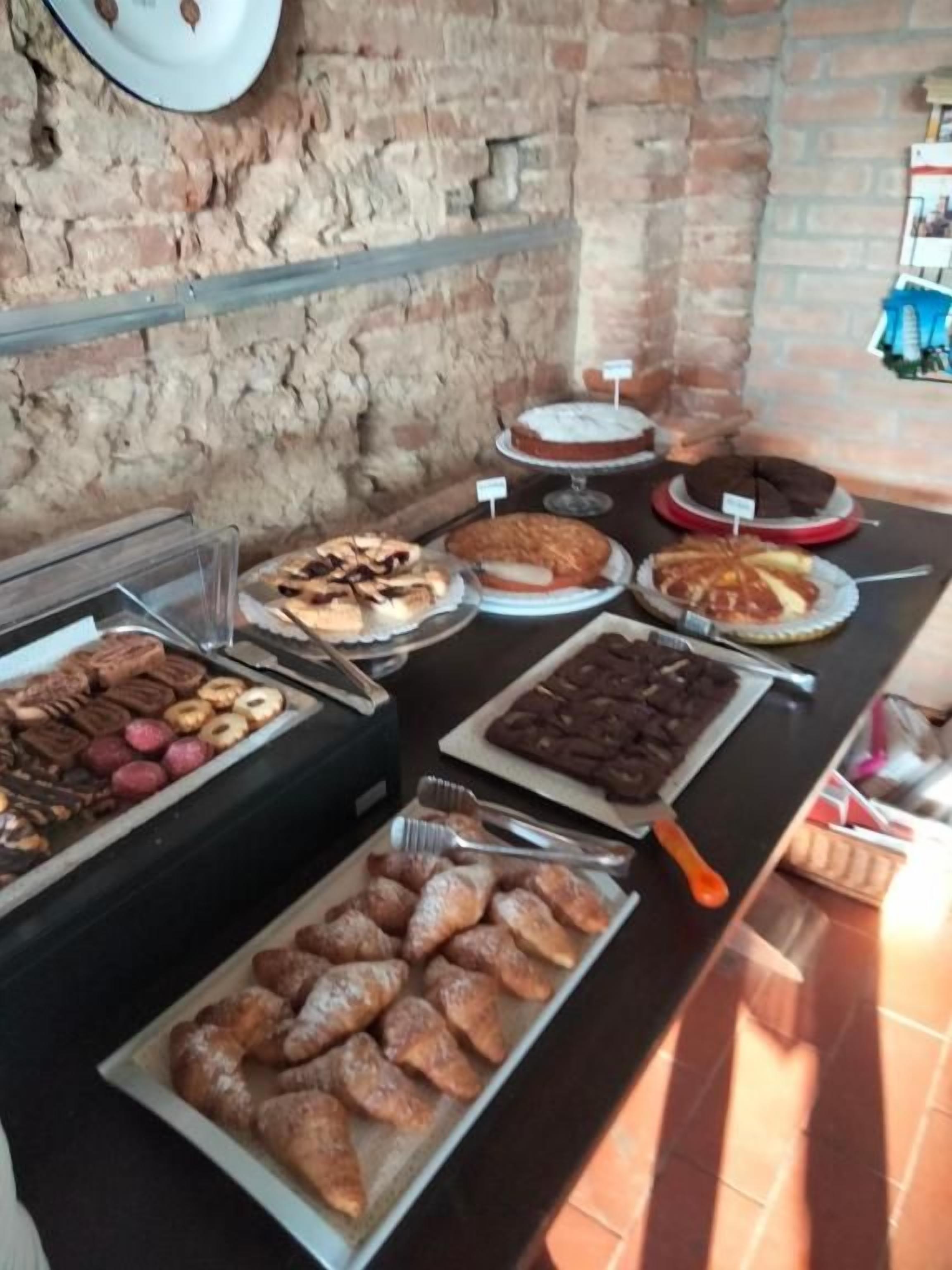 Un buffet proposant une variété de plats, notamment des viennoiseries, des gâteaux et des desserts.