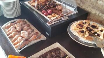 Un buffet proposant une variété de plats, notamment des pâtisseries, des desserts et une tarte.
