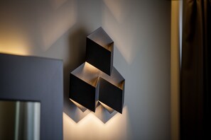 A geometric wall-mounted light fixture with three black panels.