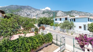 A residential area with a street, houses, and mountains in the background. - Calagonone Villa with garden bbq, WiFi / AC --- IUN Code: P2169 (Dorgali)