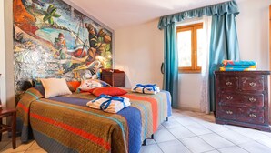 A bedroom with a large bed, a dresser, a window with curtains, and a colorful mural on the wall. - Calagonone Villa with garden bbq, WiFi / AC --- IUN Code: P2169 (Dorgali)