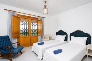 A hotel room with two beds, a chair, and a window with curtains. - Laurel - Javea, Costa Blanca (Javea)