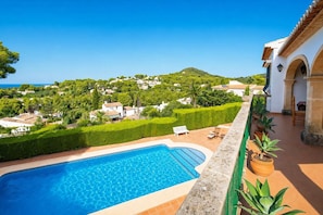 A swimming pool with a view of a hillside community.