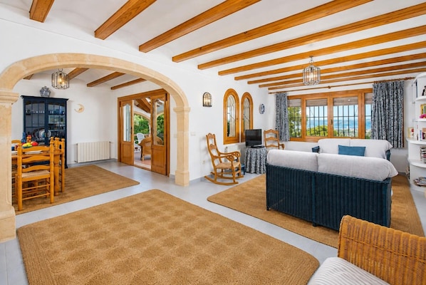 A spacious room with a bed, a dining area, and a view of the outdoors.