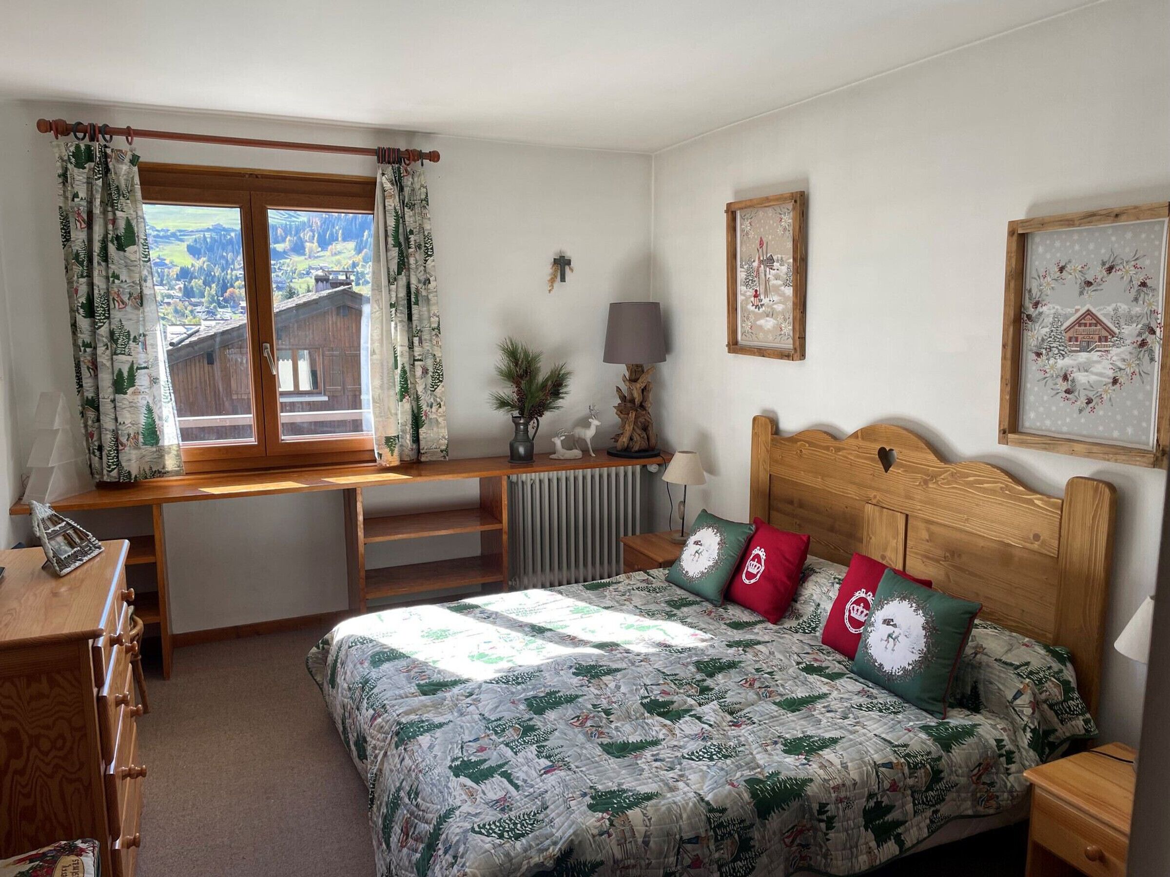 Una camera da letto con una scrivania in legno, un letto con copriletto e una finestra con tende.