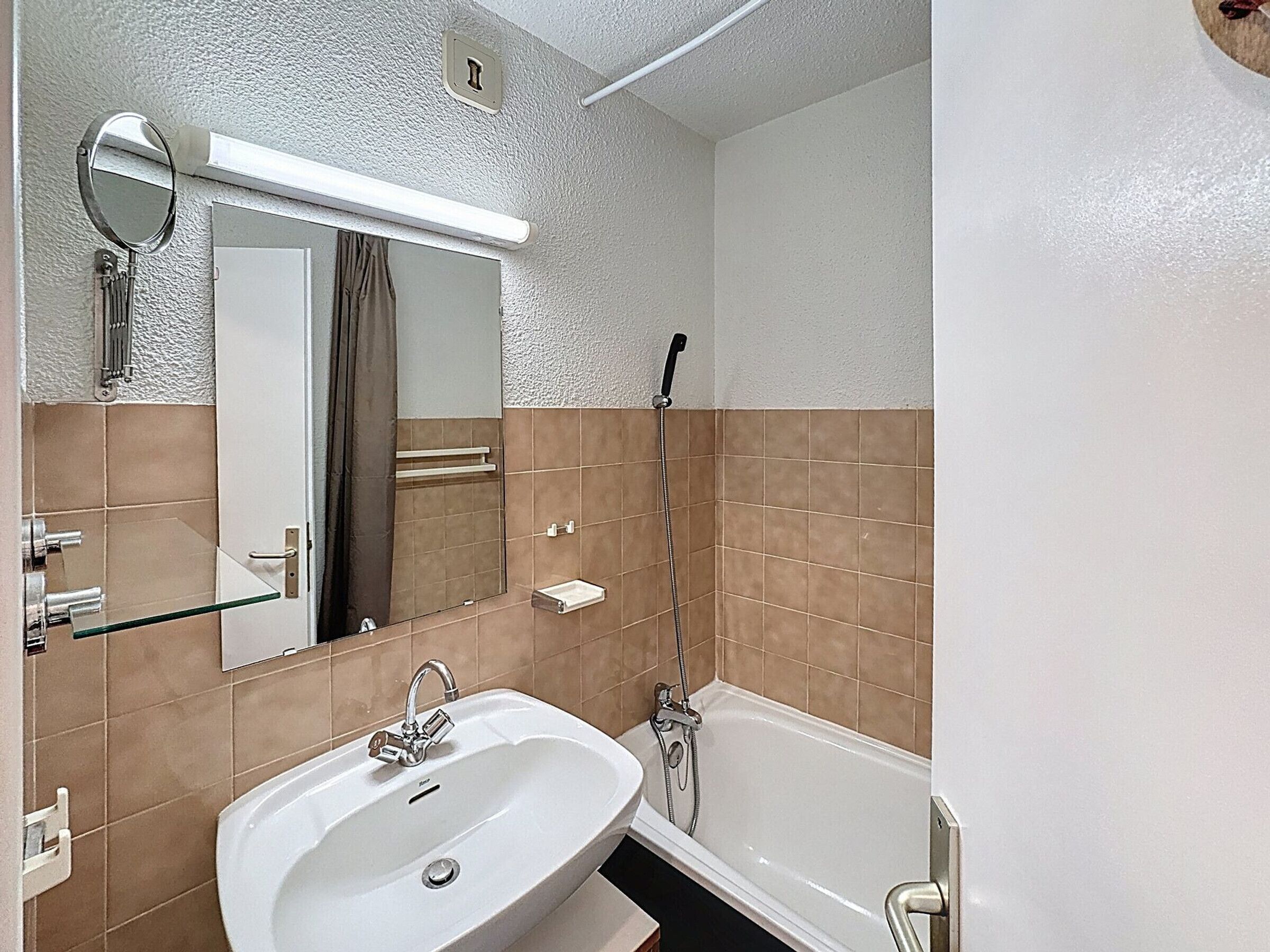 Un bagno con lavandino, specchio e doccia.
