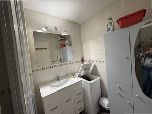 A bathroom with a sink, mirror, and a white cabinet with drawers. - Cozy T2 Apartment with Pool, Parking, and Close Beach Access in Argelès-sur-Mer (Argelès-sur-Mer)