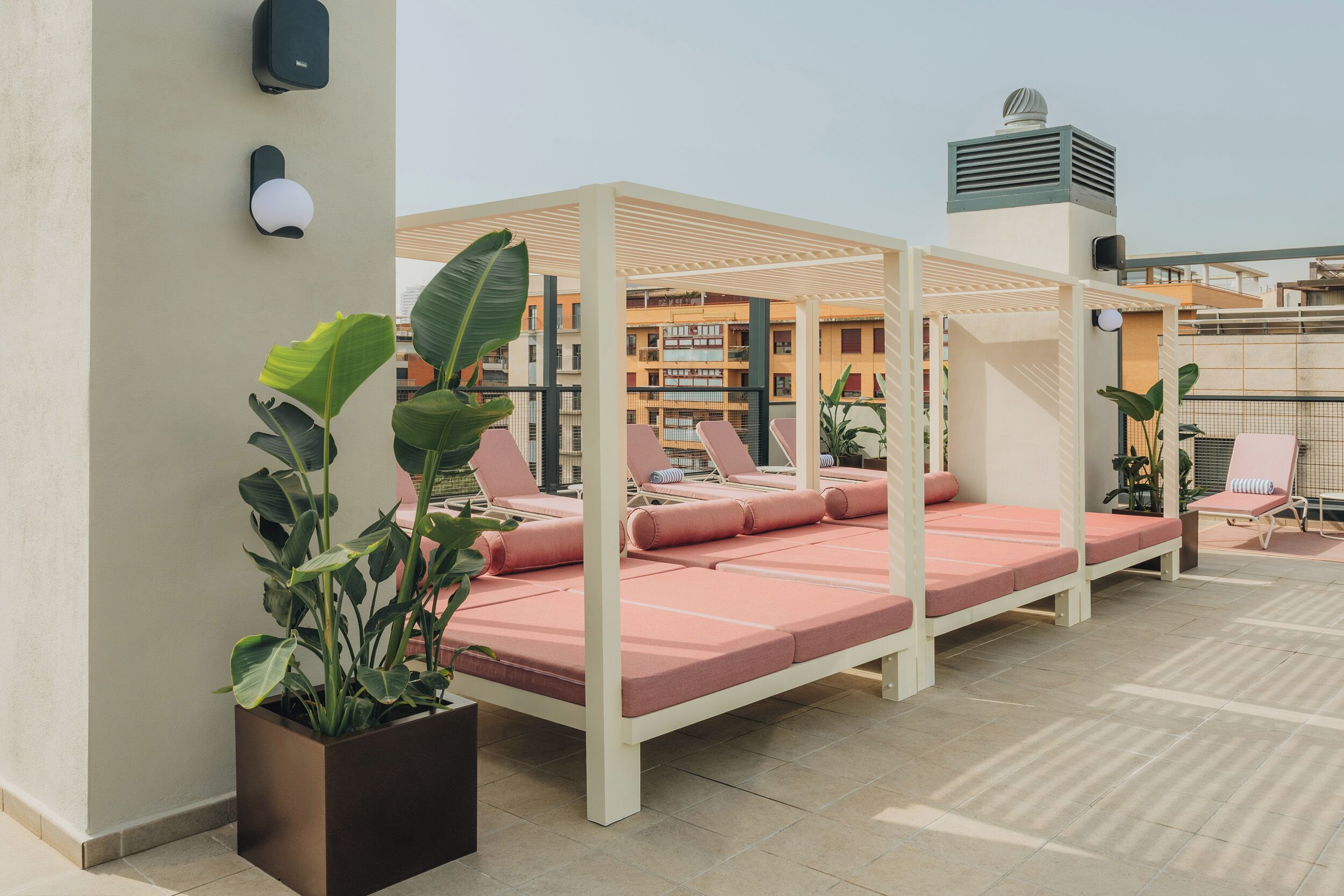A rooftop terrace with outdoor seating and potted plants.