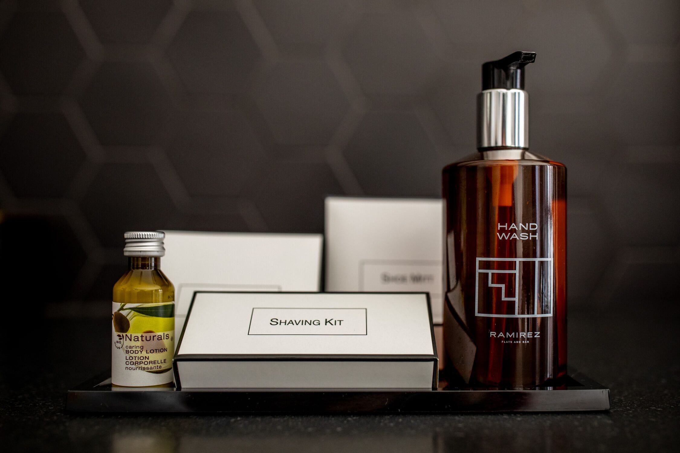 A shaving kit with a bottle of lotion and a hand wash bottle on a tray.