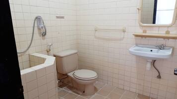 Un baño pequeño con azulejos, un inodoro, un lavabo y una ducha.
